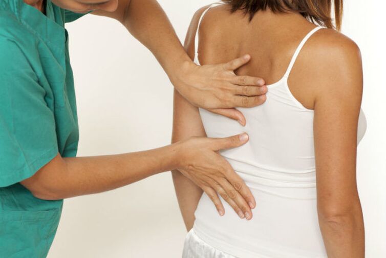 El médico examina la espalda con dolor debajo del omóplato izquierdo