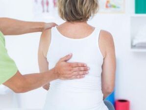 Un médico examina a un paciente con quejas de dolor de espalda en la zona del omóplato. 